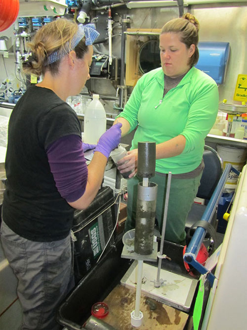 Amanda Demopoulos and Espirit Saucier in the wet lab, carefully measure and remove layers of the smaller core sampling into separate containers for later analysis.