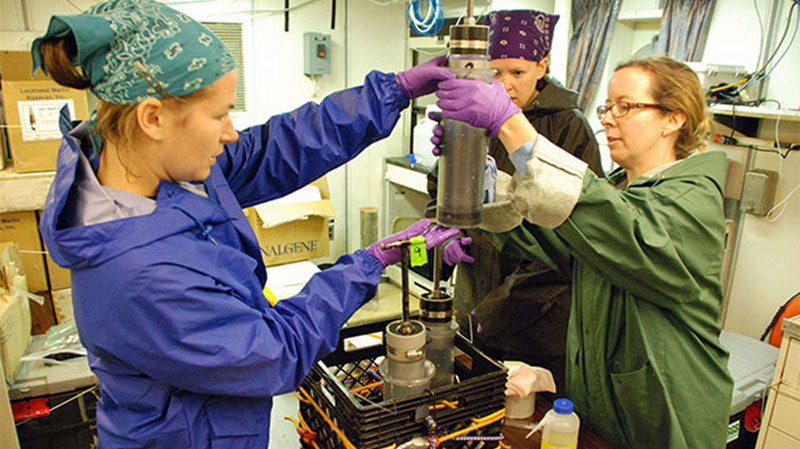 U.S. Geological Survey scientists (L to R) Jennifer McClain-Counts, Jill Bourque, and Amanda Demopoulos prepare to extract a sediment sample from one of the push cores deployed by the Jason II remotely operated vehicle.