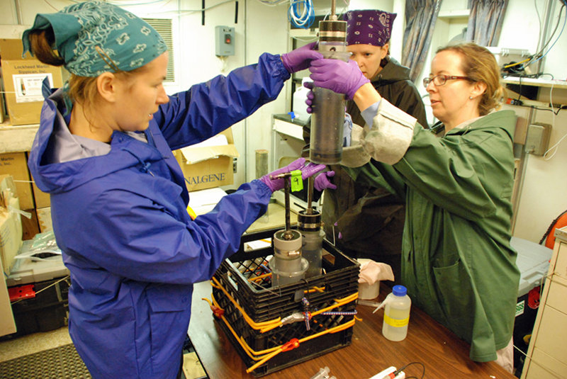 (L to R) Jennifer McClain-Counts, Jill Bourque, and Amanda Demopoulos prepare to extract a sediment sample from one of the push cores deployed by Jason.