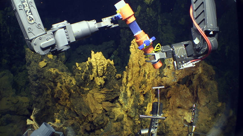 Jason opens a valve at the top of one of the scoop samplers before taking a sample of microbial mat.