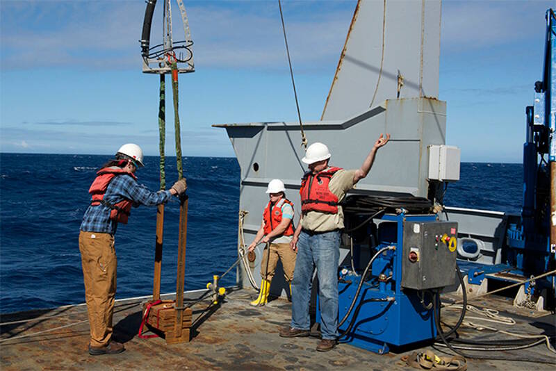 A team prepares a weight to go over the stern of R/V Thomas G. Thompson to test repairs to the winch.