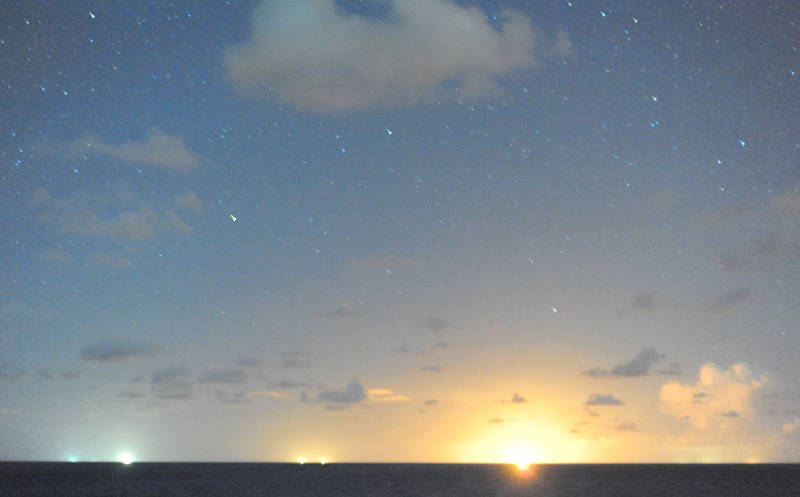 Figure 2: This is not a tropical sunset, though we have seen many beautiful ones. Note that you can see the stars, which you can’t during a real sunset. Instead, the ‘sun’ is actually a distant fire from an oil well, and the picture was taken at 11 PM under a dim crescent moon. The moonlight was just bright enough to make the sky blue, the way the sunlight makes the day sky blue. This photo was taken using a Nikon D700 from the bow of the RV Pelican. The ship was – as always – rolling in the waves, so the exposure had to be short, which shows you just how sensitive this camera is. It can literally turn night into day and is perfect for photographing bioluminescence.