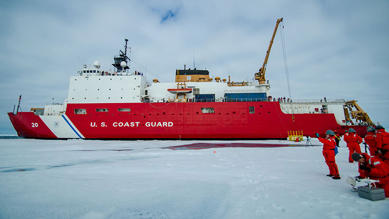The USCGC Healy sits close to an ice floe at Station 7 while members of the media team take video and photos.