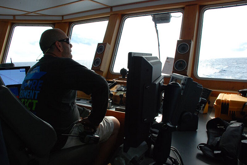 One of the captains of the R/V Baseline Explorer, Larry Bennett, commandeers the ship. Image courtesy of NOAA.
