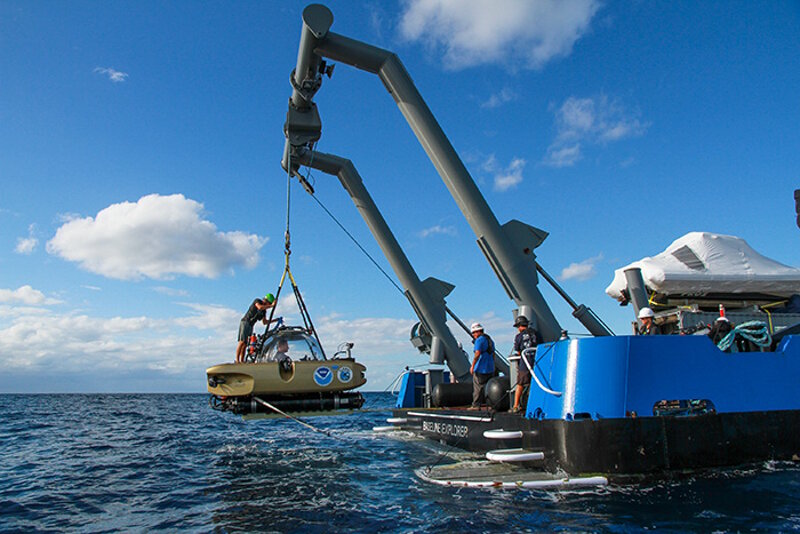 The submersible is being lifted out of the water after a dive to be parked onboard the R/V Baseline Explorer.
