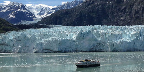 A cruise ship, frequent visitors to Glacier Bay National Pack, sails close to the edge of the glacier.