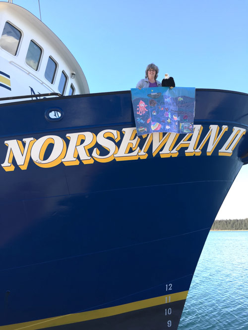 Qanuk looks out over the ship's bow.