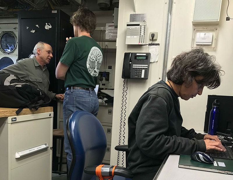 Chief Scientist Martha Nizinski discusses the cruise plan with Dave Packer while Co-chief Anna Metaxas takes care of last minute details in the Bigelow's dry lab.