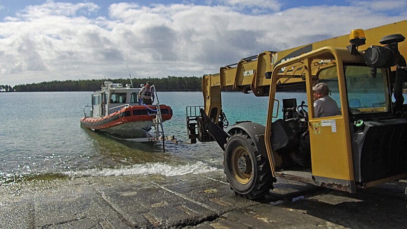 The team launches the boat for remote sensing survey operations at Midway Atoll.
