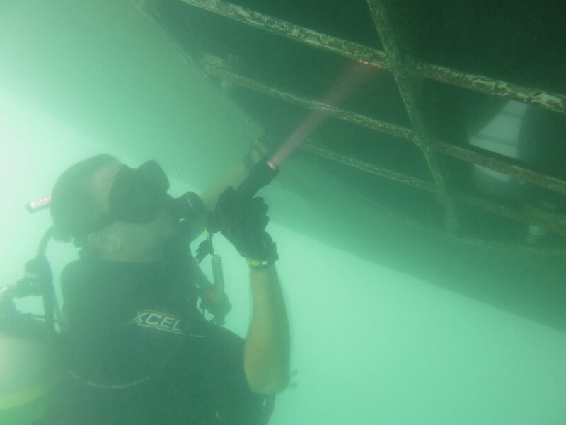 A diver conducting a hull inspection for Monument entry.