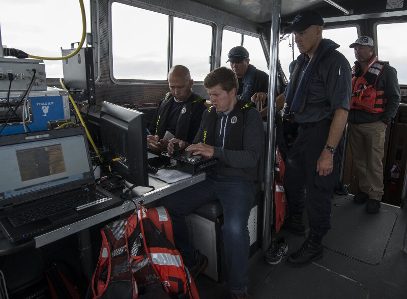 Hans VanSumeren (left, front) and John Lutchko (right, front) of Northwest Michigan College work together while piloting an ROV during investigations of newly discovered shipwreck sites in Thunder Bay National Marine Sanctuary during August, 2017.