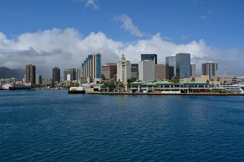 Aloha Tower (center) in Honolulu saying goodbye. It used to be the highest tower visible from the sea, welcoming new ships and giving its regards to the sailing ships. Now, it is surrounded by much higher skyscrapers.