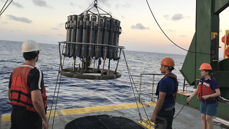 The conductivity, temperature, depth sampling package (CTD) getting ready to be deployed from the ship. The sampling bottles are affixed to the outside of a suite of instruments and the entire package is deployed on a conducting wire, providing real-time data on ocean physics and chemistry as the package descends and ascends through the water.