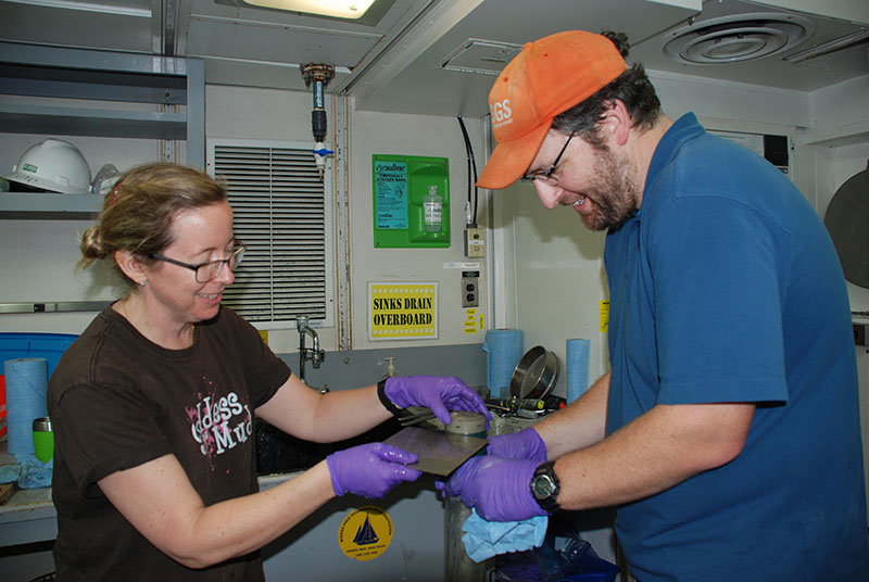 Amanda Demopoulos and Jason Chaytor section a sediment core for preservation and future analysis.