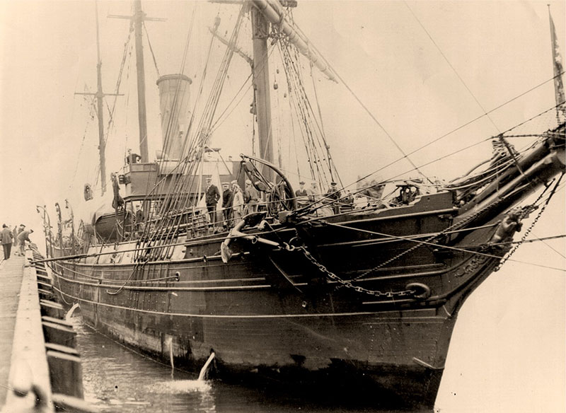 Close up of Bear mooring to a pier showing her hull and sail rig. 