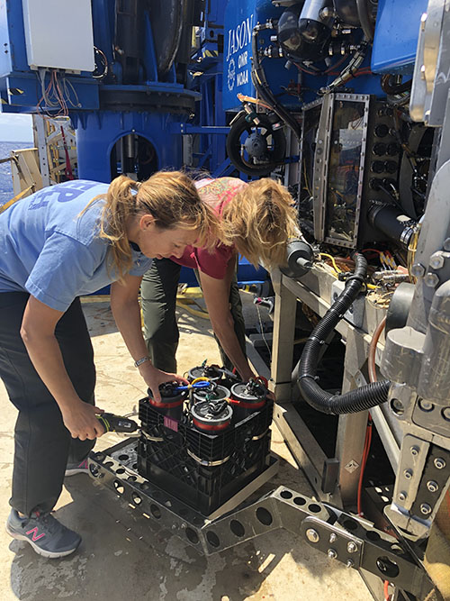 Chris Kellogg and Sandra Brooke remove coral quivers from the swing arm of ROV Jason. Coral quivers are designed to hold individual samples of coral and can even be prepared to do specialized microbial sampling, as Chris has been doing on this cruise.