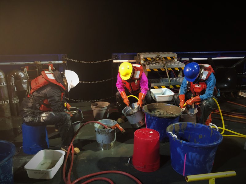 Kelly Walker (left) and her team members are busy rinsing the catch from the beam trawl during night time trawling.