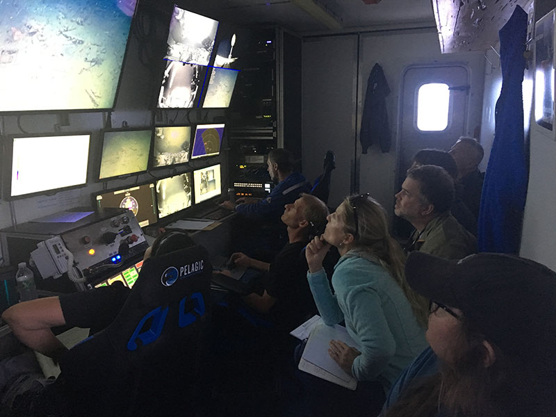 Inside the ROV control van during a dive, the ROV team and marine archaeologists work together during the investigation of an unexplored, 19th century wooden shipwreck.