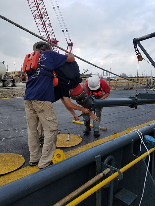 Working from a barge, the crew remove an existing sensor from an over the side mounted pole that will be used for the parametric sonar system.