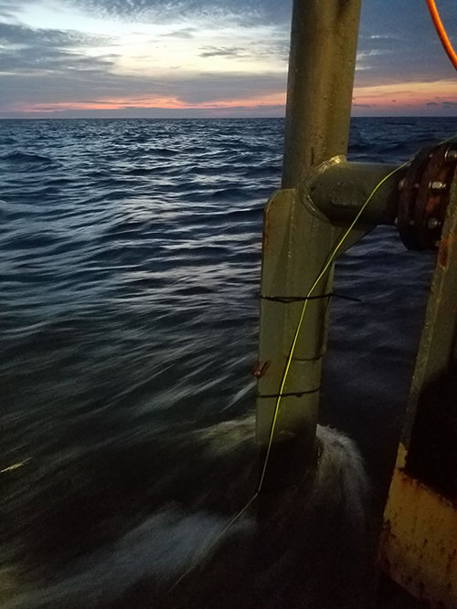 The parametric sonar pole as the vessel transits a survey line at sunset.