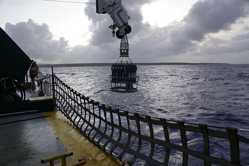 A CTD rosette is lowered into the water from Research Vessel Kilo Moana. A CTD measures conductivity, temperature, and depth. Measurements are collected throughout the water column, from the ocean surface as the instrument is lowered to near the seafloor, and then on the way back to the surface. This image was taken during the Deepwater Surveys of World War II U.S. Cultural Assets in the Saipan Channel expedition.
