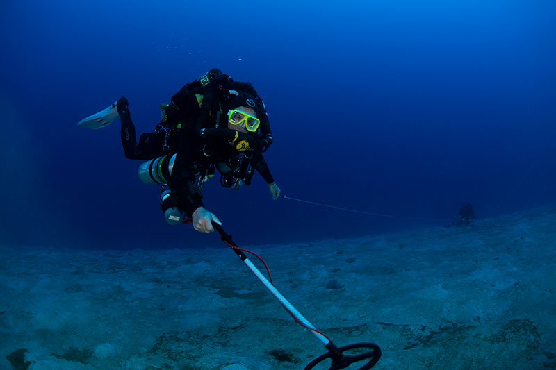 Mikey Kent with the NOAA Diving Program completes an underwater circle search for a magnetic anomaly using a metal detector.