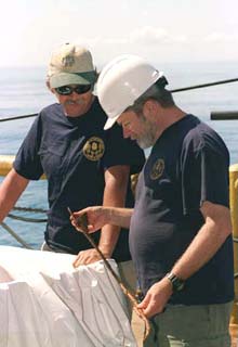 John Broadwater and Jeff Johnston examining a lubrication cup from the Monitor's ventilation blower engines