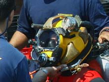Navy diver being "hatted up" for a dive