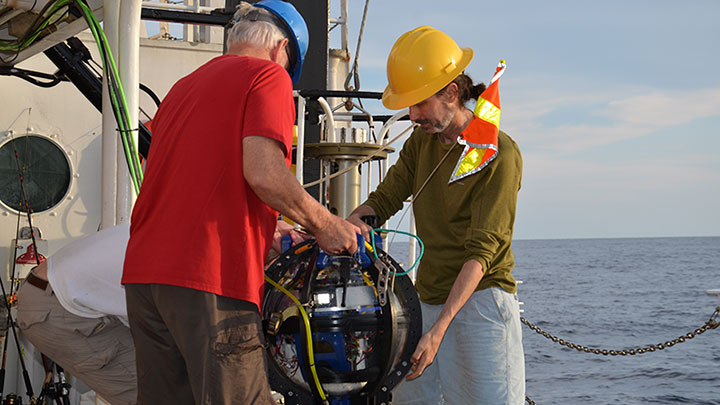 In this image, a member of the glider team helps a member of the Driftcam team move the Driftcam after it was retrieved from sea.