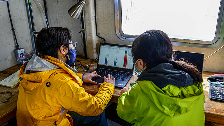 Coordinated Simultaneous Physical-Biological Sampling Using ADCP-Equipped Ocean Gliders principal investigator Wu-Jung Lee and research assistant Linda Nguyen analyze data coming in from the ship’s mounted echosounder.