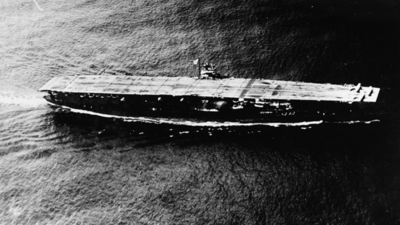 Akagi at sea during the Summer of 1941, with three Mitsubishi A6M Zero fighters parked forward.