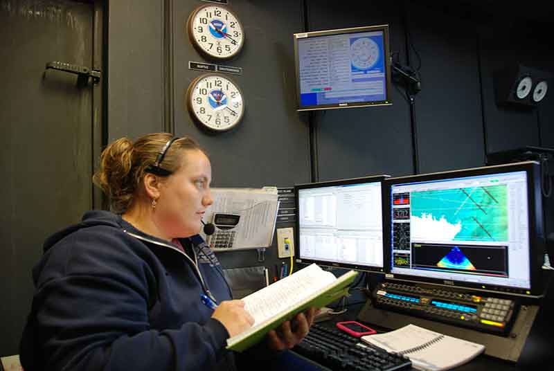 Senior Survey Technician Colleen Peters makes an entry in the mapping watch log book.