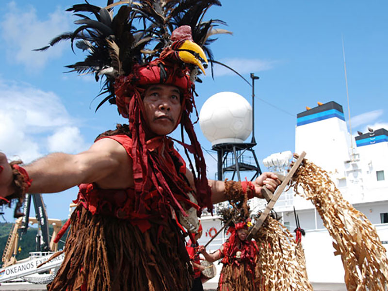 One of the traditional dancers in the Welcoming Ceremony poses in front of the NOAA Ship Okeanos Explorer.