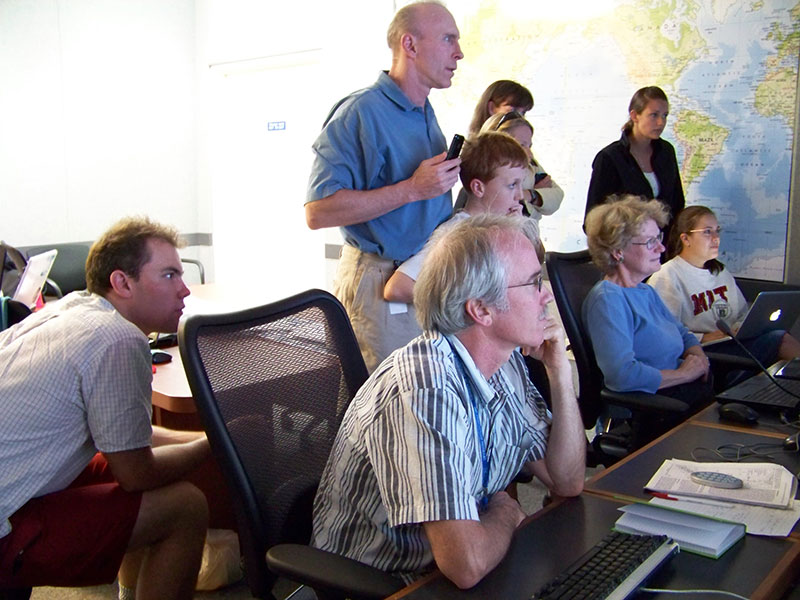 Scientists and spectators located at the Seattle Exploration Command Center intently watch live video being streamed from the Little Hercules ROV.