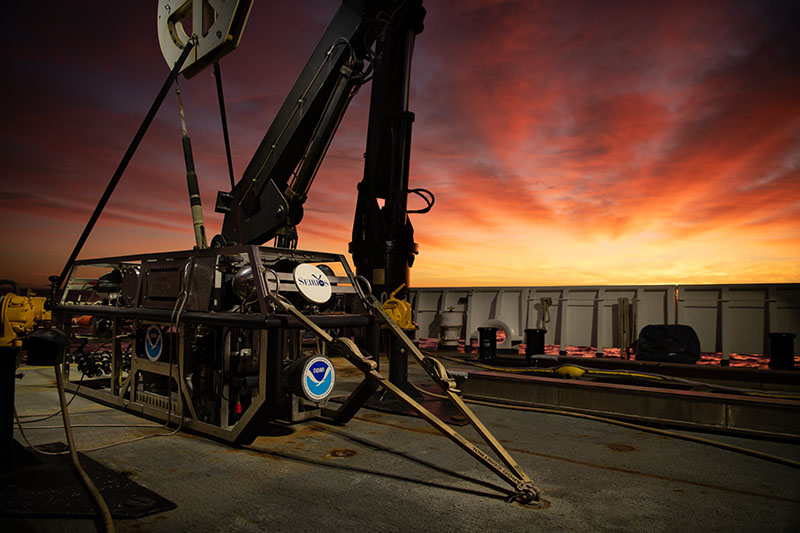 The sun rises over remotely operated vehicle Seirios on the back deck of NOAA Ship Okeanos Explorer, marking the dawn of a new day of exploration and discovery.