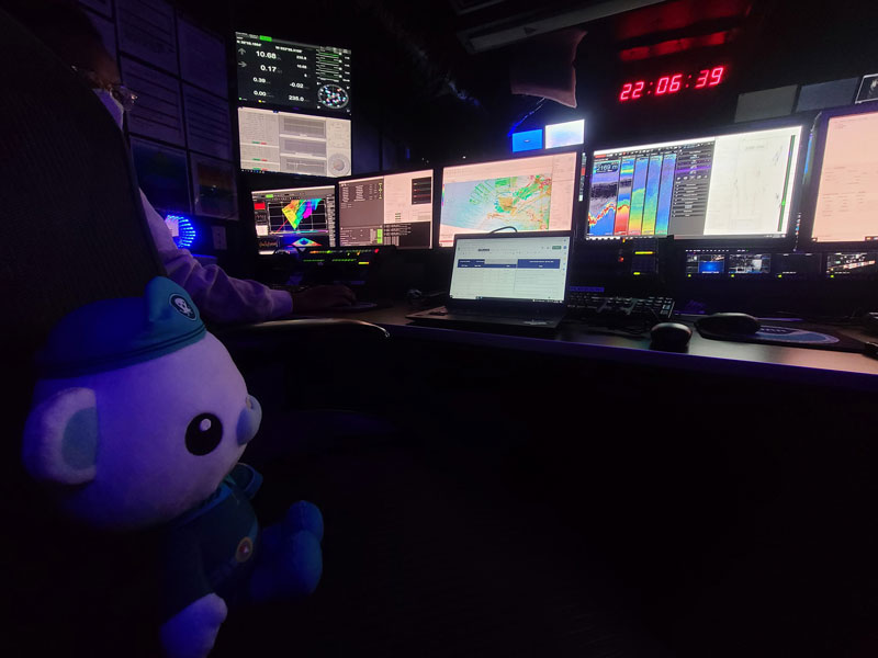 To help NOAA Ocean Exploration reach a younger audience, during the third Voyage to the Ridge 2022, the team was joined by a special guest — Captain Barnacles, captain of the Octonauts and a very brave polar bear. Here, Captain Barnacles watches mapping operations from the control room of NOAA Ship Okeanos Explorer.