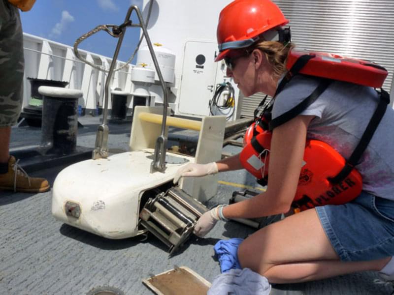 Lora Clarke (NMFS) loads a cassette containing silk mesh into the body of the Continuous Plankton Recorder on the deck of the NOAA Ship Okeanos Explorer during the trip from Guam to Hawaii last month. The metal fitting on the nose allows water and plankton to be strained through the silk mesh in the cartridge.