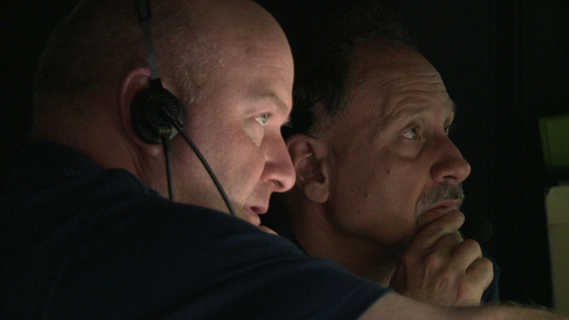 ROV Team Coordinator Dave Lovalvo and Science Team Lead Tim Shank discuss upcoming operations in the NOAA Ship Okeanos Explorer Control Room.