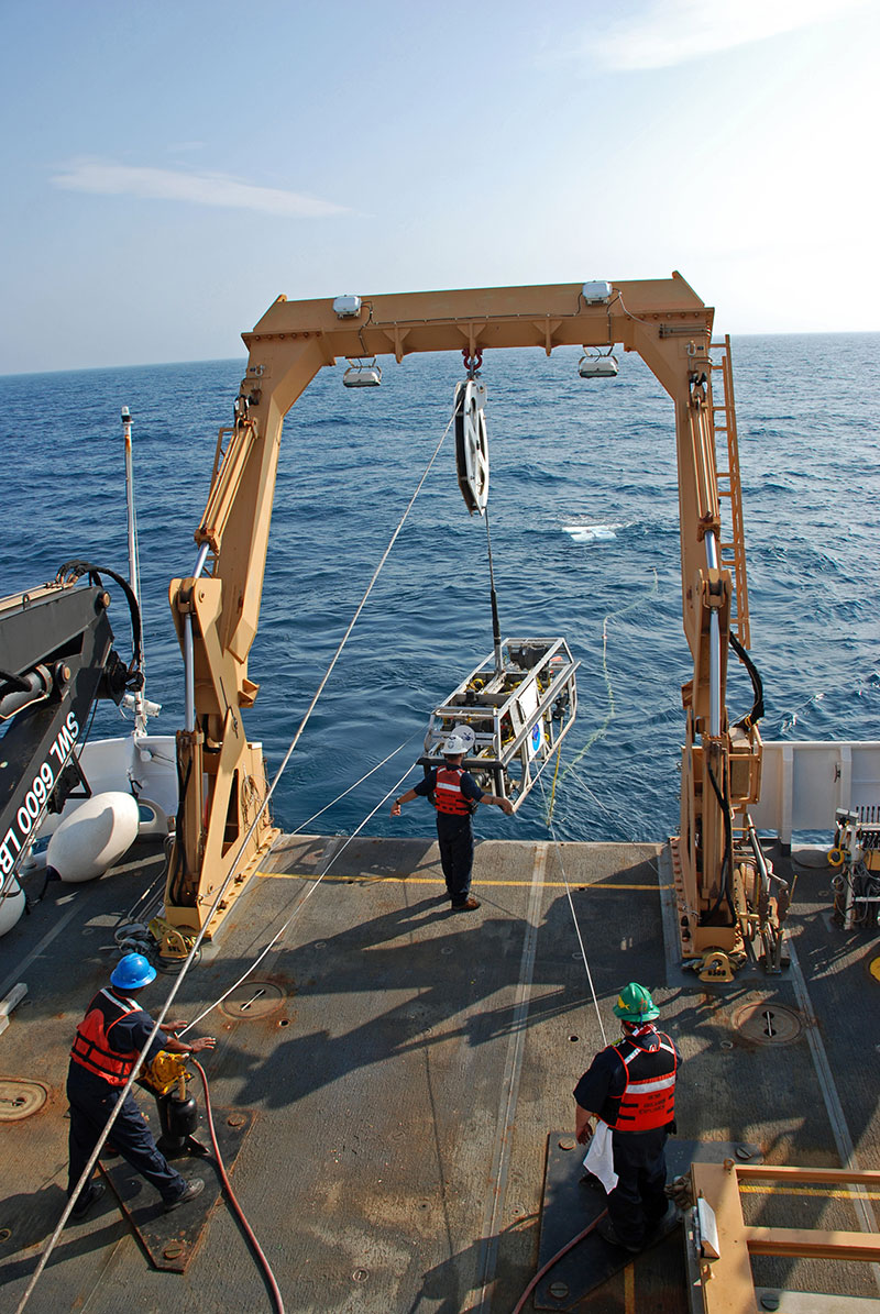 AB Kelson Bracey (left), BGL Jerrod Hozendorf (center) and AB Doug McKay (right) launch Camera Sled Seirios from NOAA Ship Okeanos Explorer.