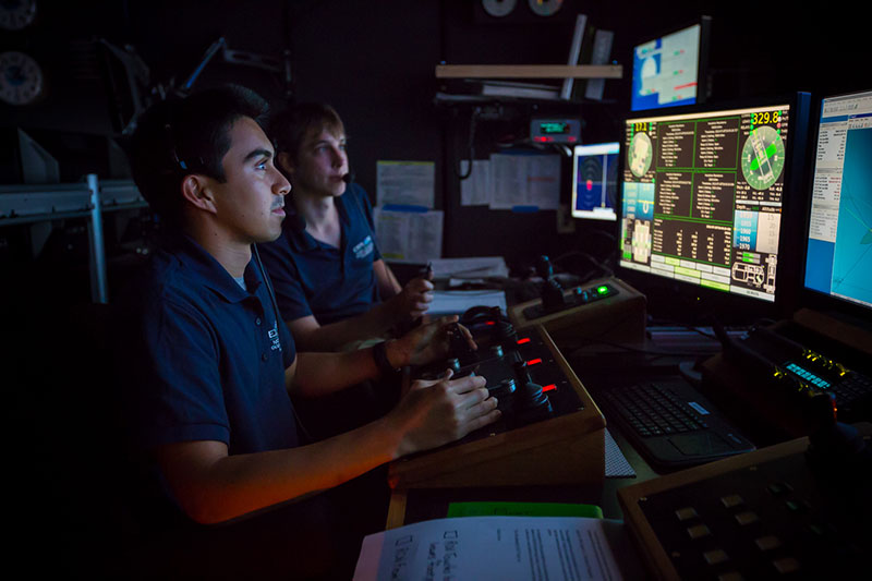 Anthony Sylvester (left) pilots ROV Deep Discoverer for the first time while Bobby Mohr watches from the navigator position.