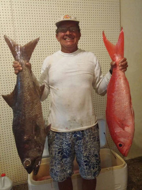 Mr. L Román holding a catch of (on left) Atlantic Scombrops (Scombrops oculatus) and (on right) Cartucho (Etelis oculatus) (Photo: L. Román)