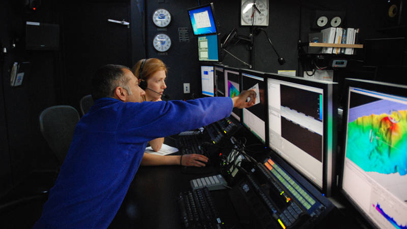 Explorers in Training Mike Barber and Kate von Krusenstiern process and clean data during the transit north to dry dock.
