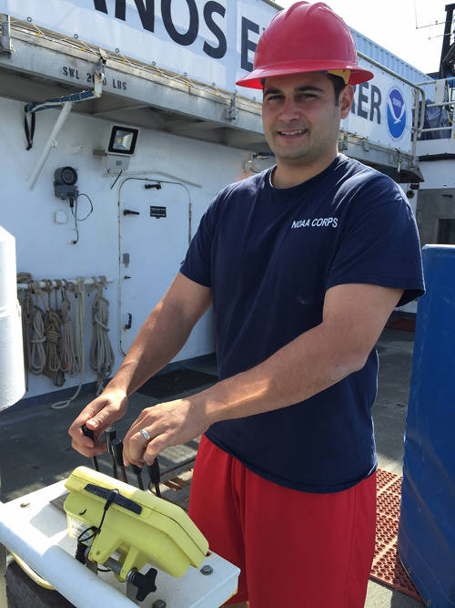 ENS Nick Pawlenko helps load stores aboard the Okeanos Explorer.