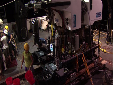 Following safe recovery of the ROV, Biology Science Team Lead Diva Amon prepares to retrieve the samples from ROV D2 while the deck team starts to assess the sheave located at the forward end of the aft deck.