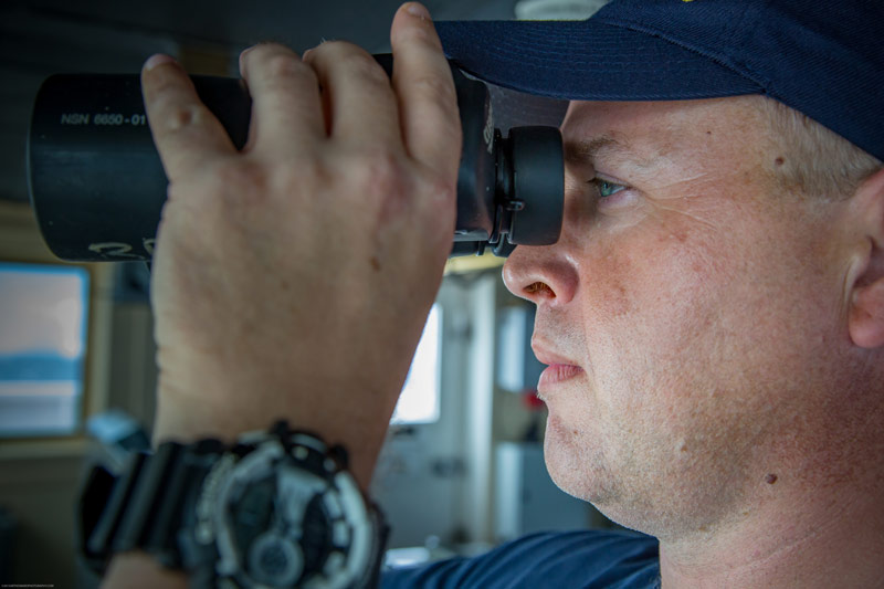 Operations Officer LTJG Aaron Colohan scans the horizon while on watch.