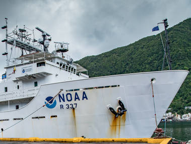 NOAA Ship Okeanos Explorer docked at the pier at the Port of Pago Pago in American Samoa. Significant outreach was conducted prior to commencing the expedition. Interviews were conducted with media, and ship tours were held for local elementary through college students, local partners, government and agency representatives.
