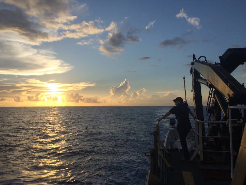 Emily Narrow enjoying the sunset after finishing her highlight video for the day on board the Okeanos Explorer.