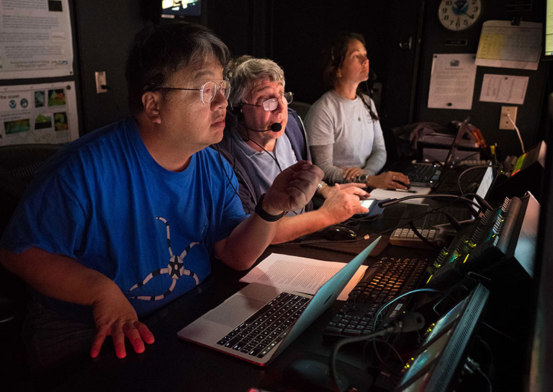 Onboard science leads Drs. Chris Mah and Chris Kelley and NOAA Educational Partnership Program Intern Nikola Rodriguez discuss and take a closer look at deepwater habitats explored with remotely operated vehicle Deep Discoverer on Horizon Guyot. 