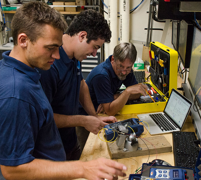 Electrical engineers Levi Unema and David Casagrande picking up on some of the finer points of fiber optic measurements from Dave Wright.