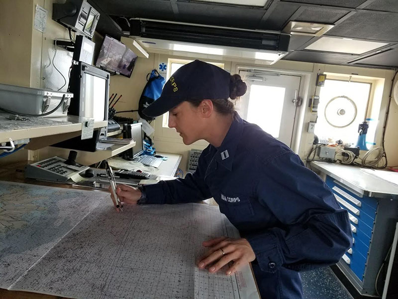 LT Abbitt plotting a fix at the charting table on the bridge of the Okeanos Explorer.
